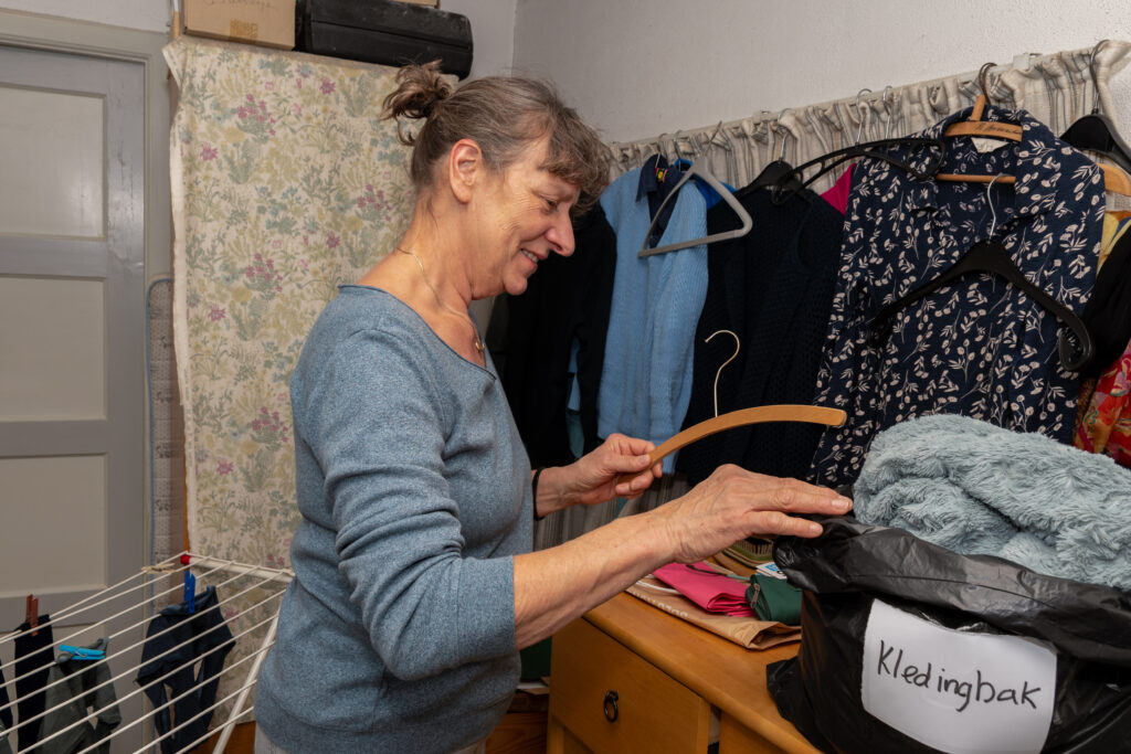 Rianne die kleding aan het opruimen is